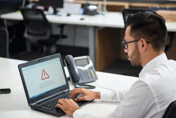 Office worker experiencing a technical issue with a computer at the desk