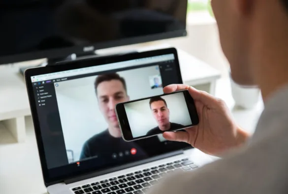 Person using VoIP phone number on laptop and smartphone for internet calls