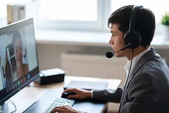 Business professional using a VoIP phone system at a workstation